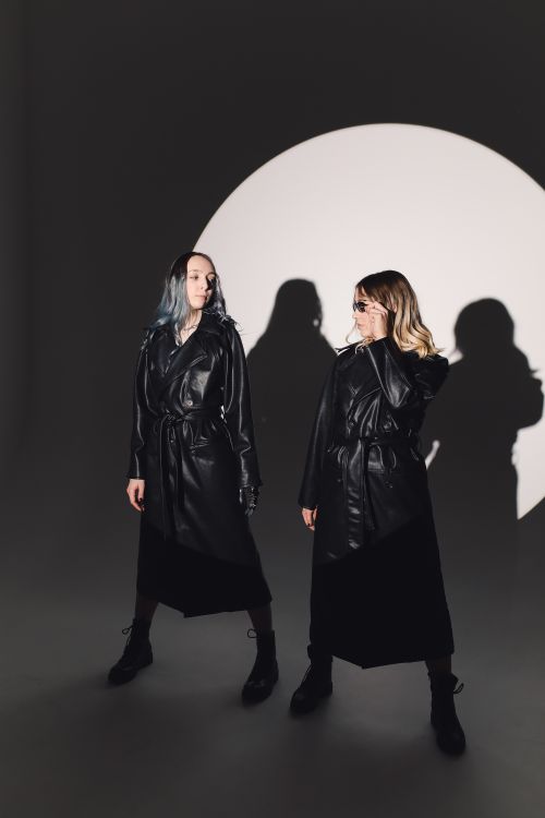 Free Two fashionable models pose in black leather coats, showcasing modern style and chic elegance in a studio setting. Stock Photo