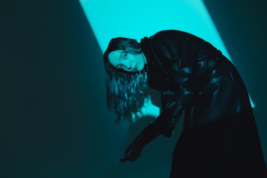 Stylish portrait of a woman in a bionic prosthetic arm under moody blue lighting.