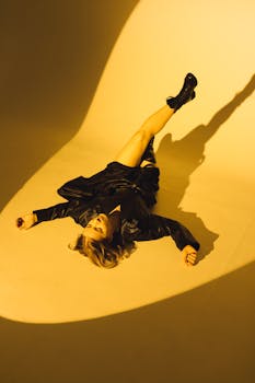 Stylish woman posing in black leather under dramatic lighting indoors.