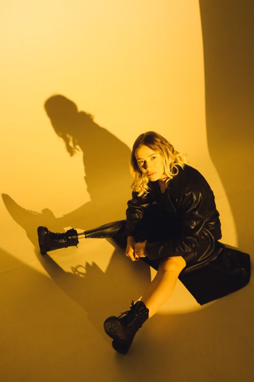 Free Fashionable woman in black leather and prosthetic leg in studio lighting. Stock Photo