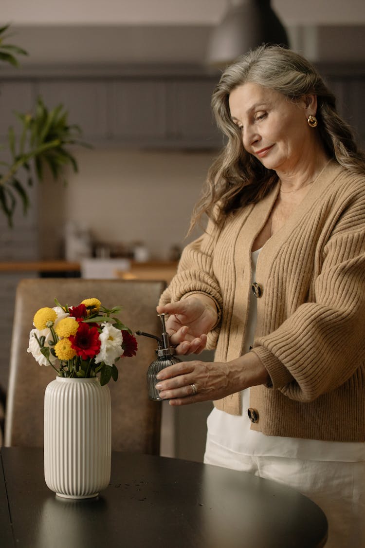 Woman Watering A Bouquet Of Flowers