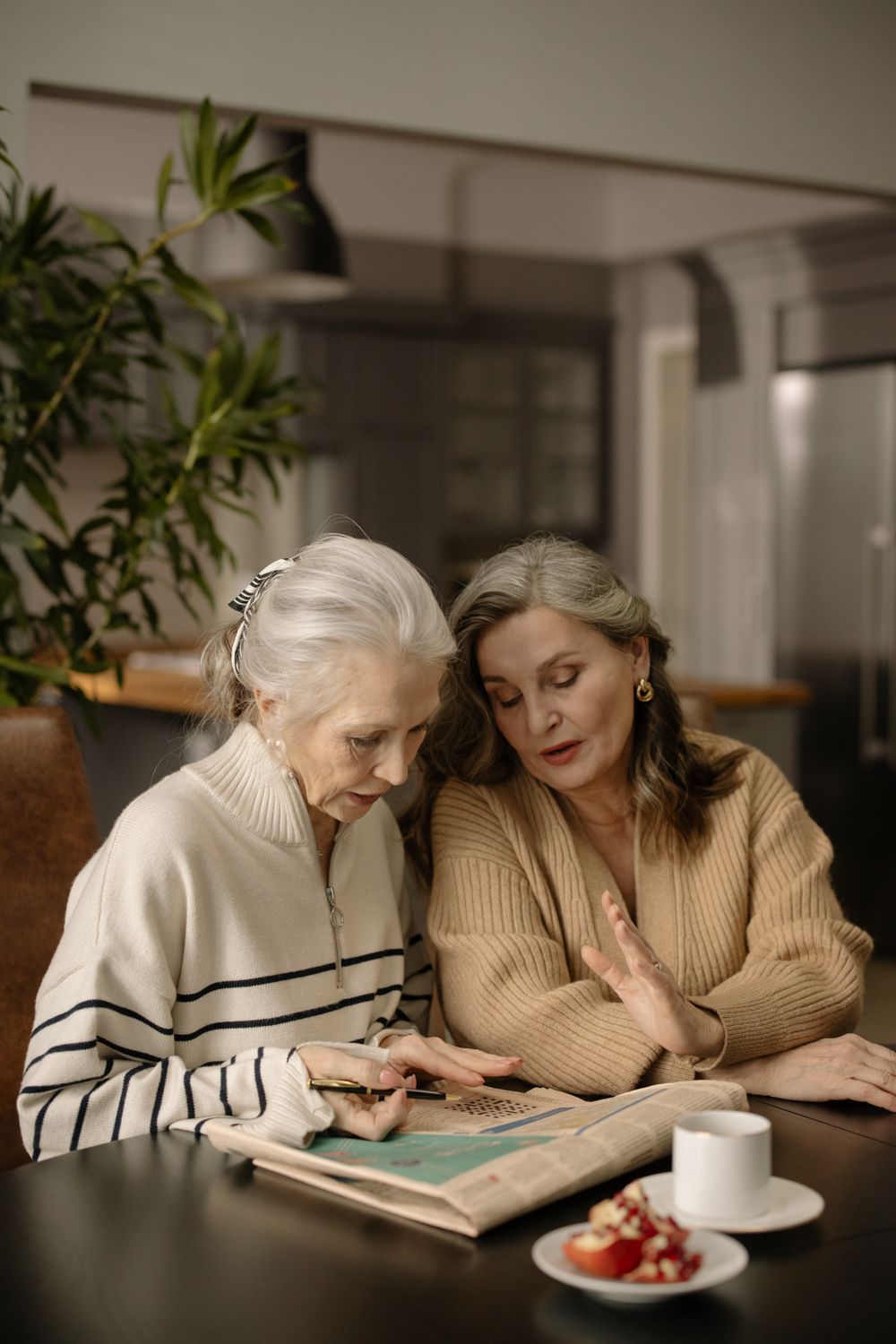 Two senior women enjoying a crossword puzzle together