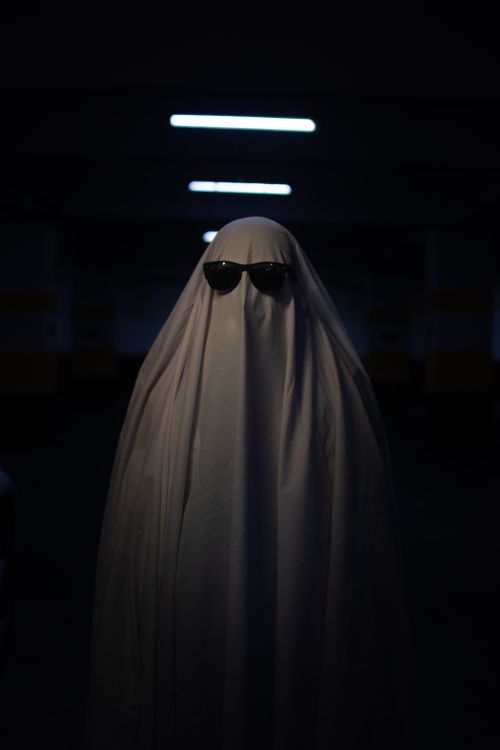 Free A ghostly figure wearing sunglasses covered in a white sheet, creating a mysterious ambiance. Stock Photo