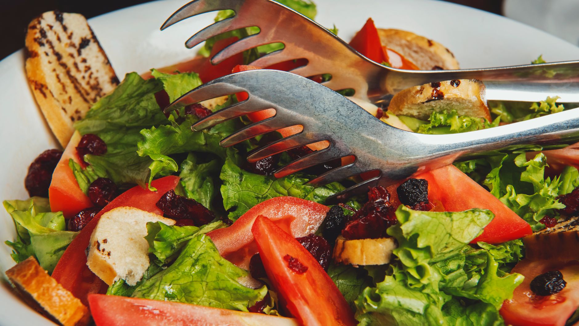 Green salad with cranberry vinaigrette served in a white bowl