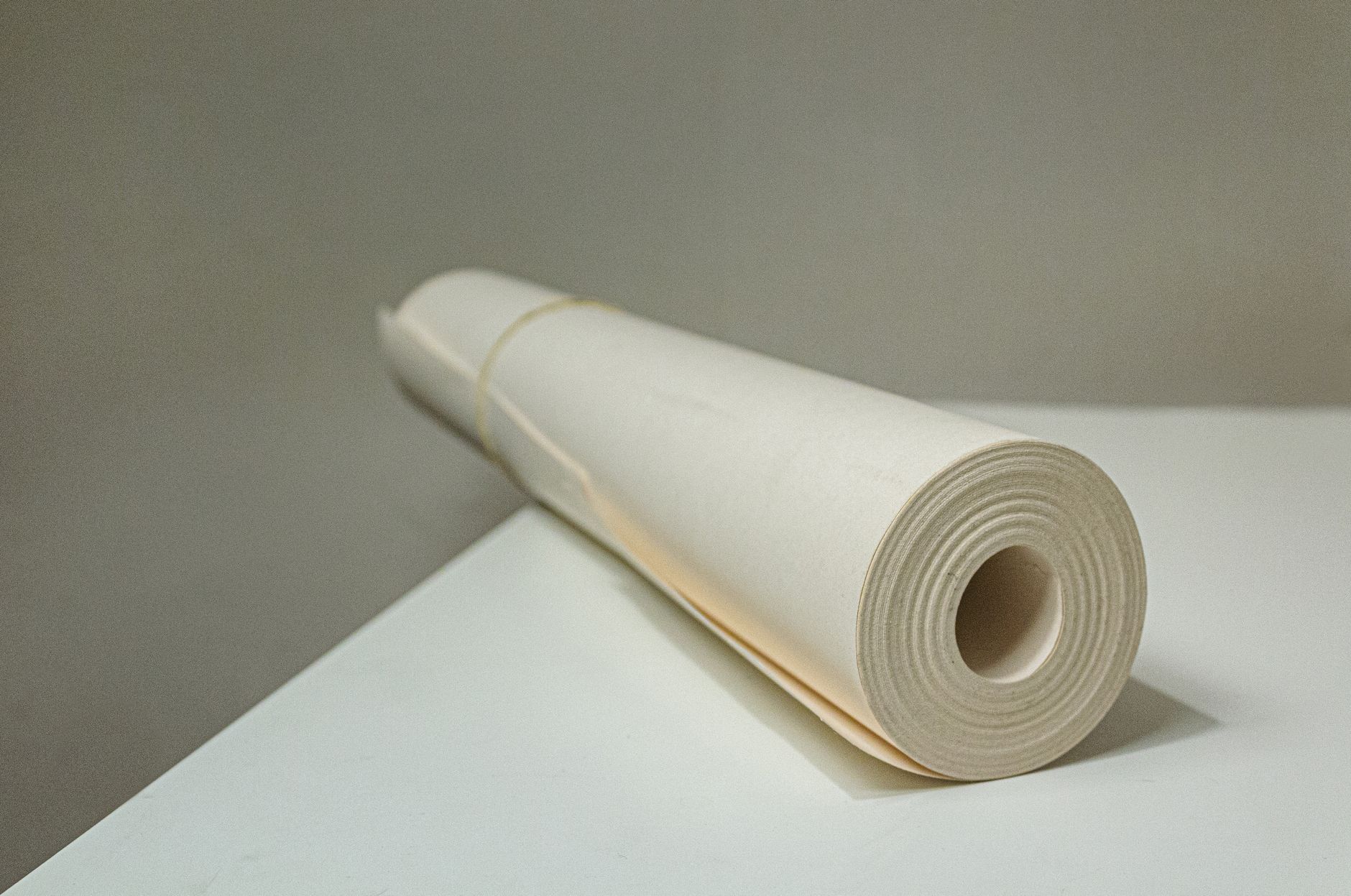 Close-up view of a rolled white paper on a desk, showcasing simplicity and texture.