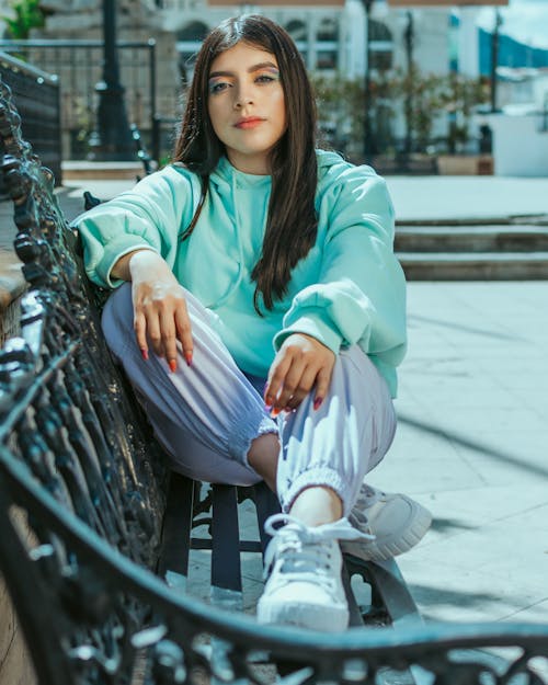 Woman Wearing Hoodie Sitting on a Bench