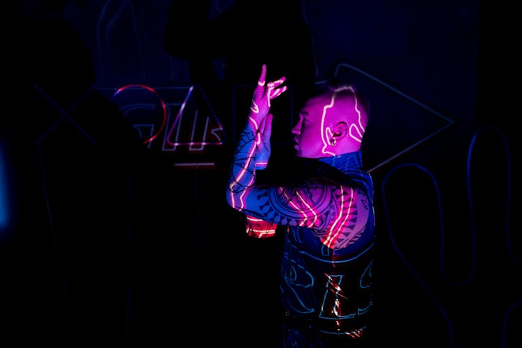 Neon Lights Projected Towards A Tattooed Man