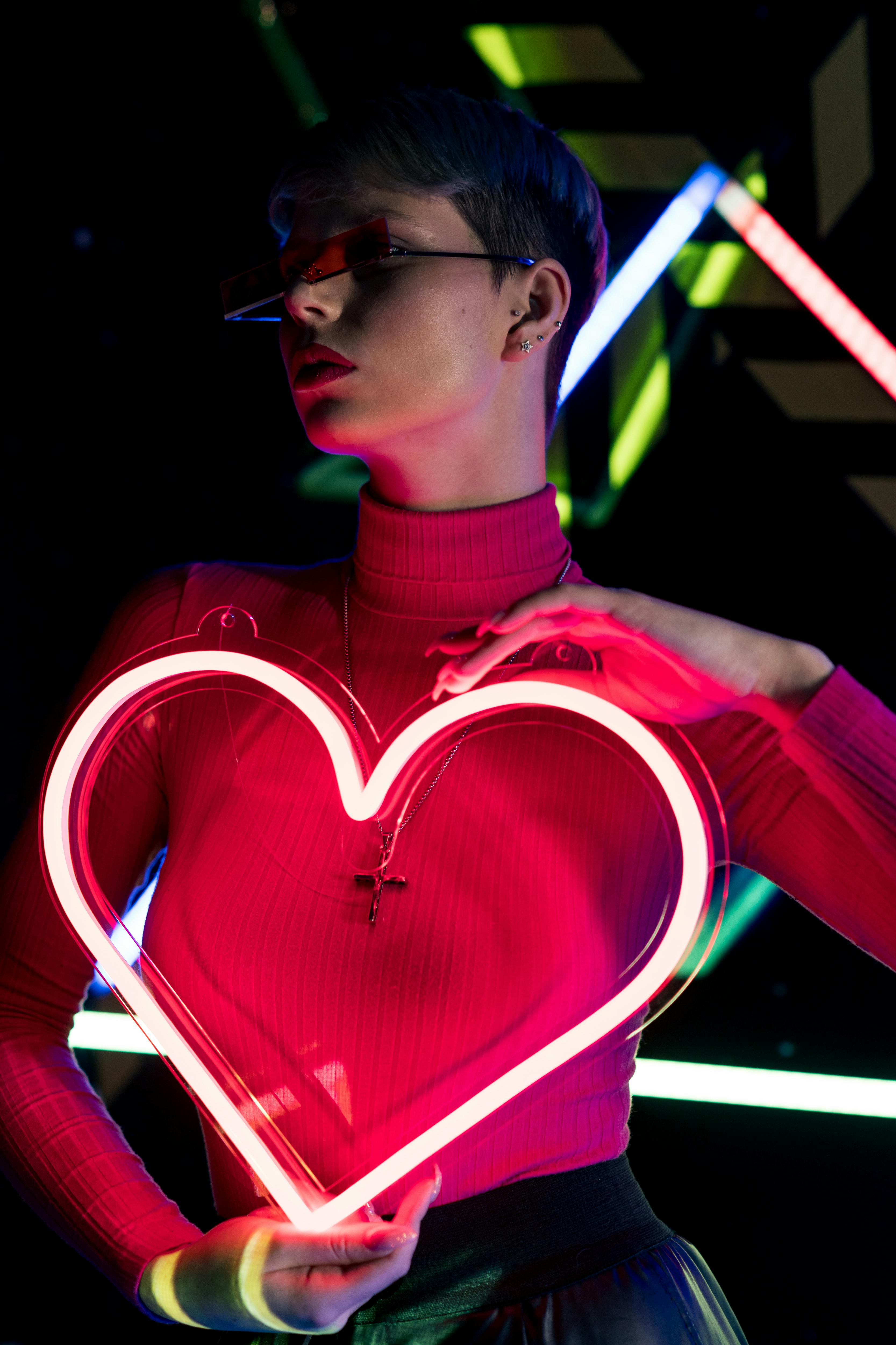 Close-Up Shot of a Woman in Turtle Neck Holding an Illuminating Heart ·  Free Stock Photo