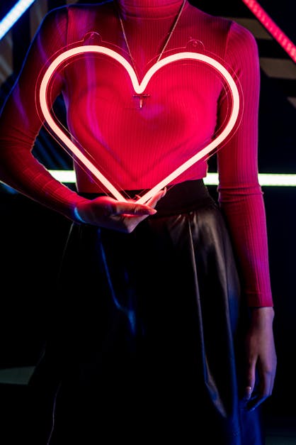 Close-Up Shot of a Woman in Turtle Neck Holding an Illuminating Heart ·  Free Stock Photo