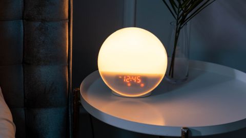 Sleek bedside table featuring a glowing orb alarm clock, perfect for a stylish bedroom.