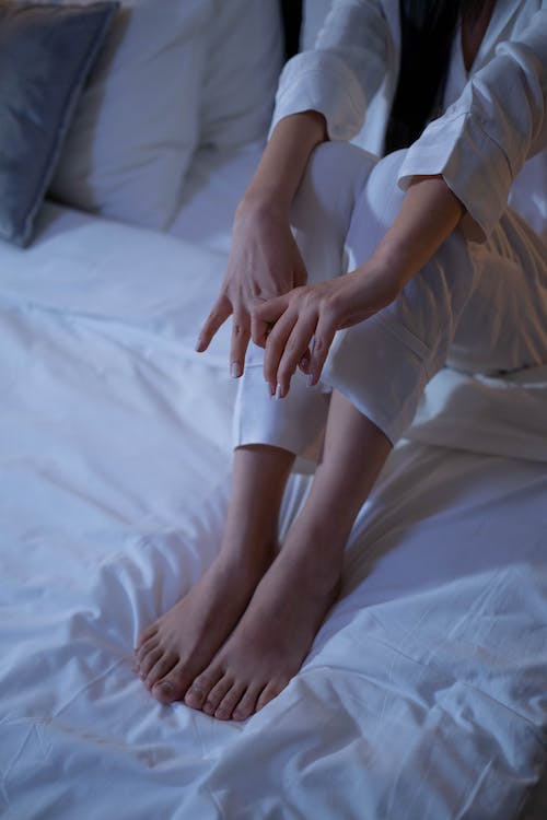 Person in Sleepwear Sitting on a Bed