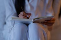 Close-Up Shot of a Person Writing on a Notebook