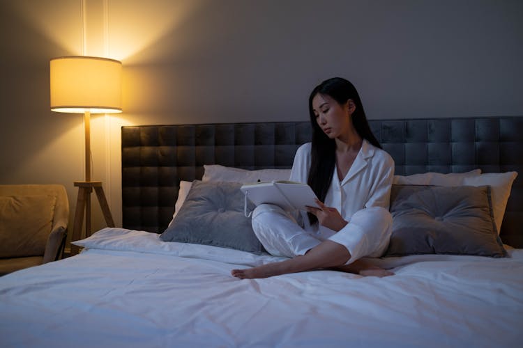 Woman Sitting On A Bed