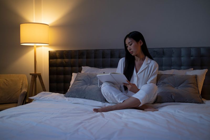 A person writing in a journal by lamp light at night — cottonbro studio on Pexels