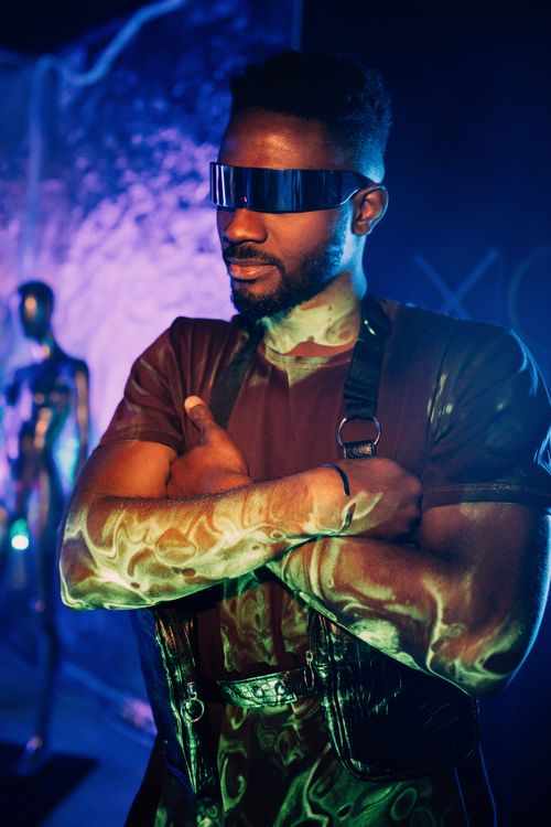 Free A confident man wearing a cyberpunk style with futuristic glasses in vibrant lighting. Stock Photo