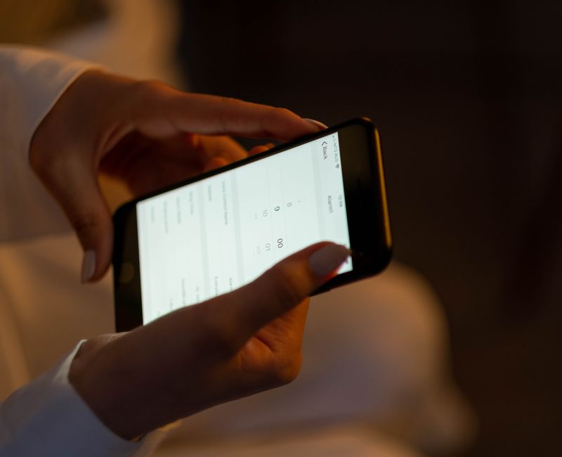 A person using a mental health app on a smartphone in a cozy setting.