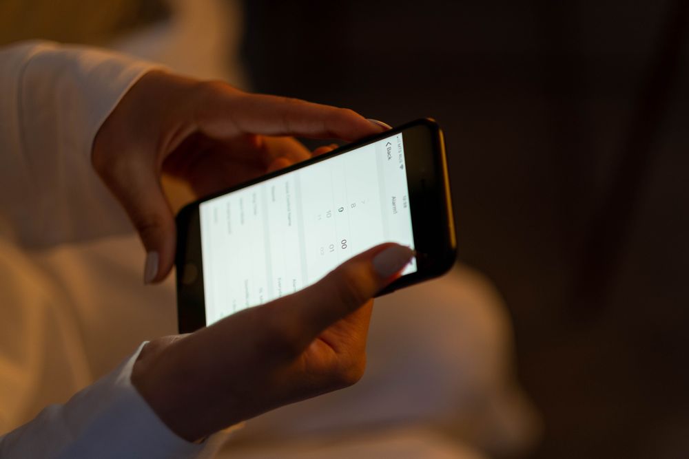 Hands using a phone to set medication reminders