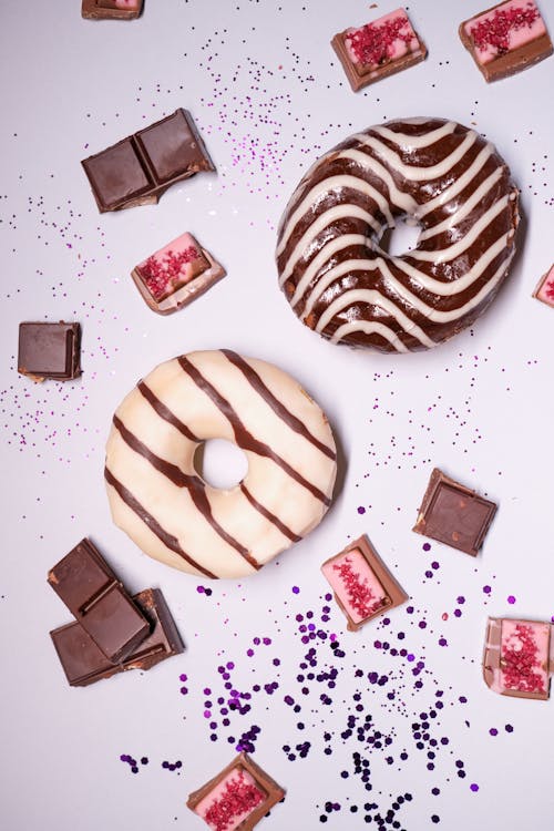 Delicious donuts with candies scattered on table