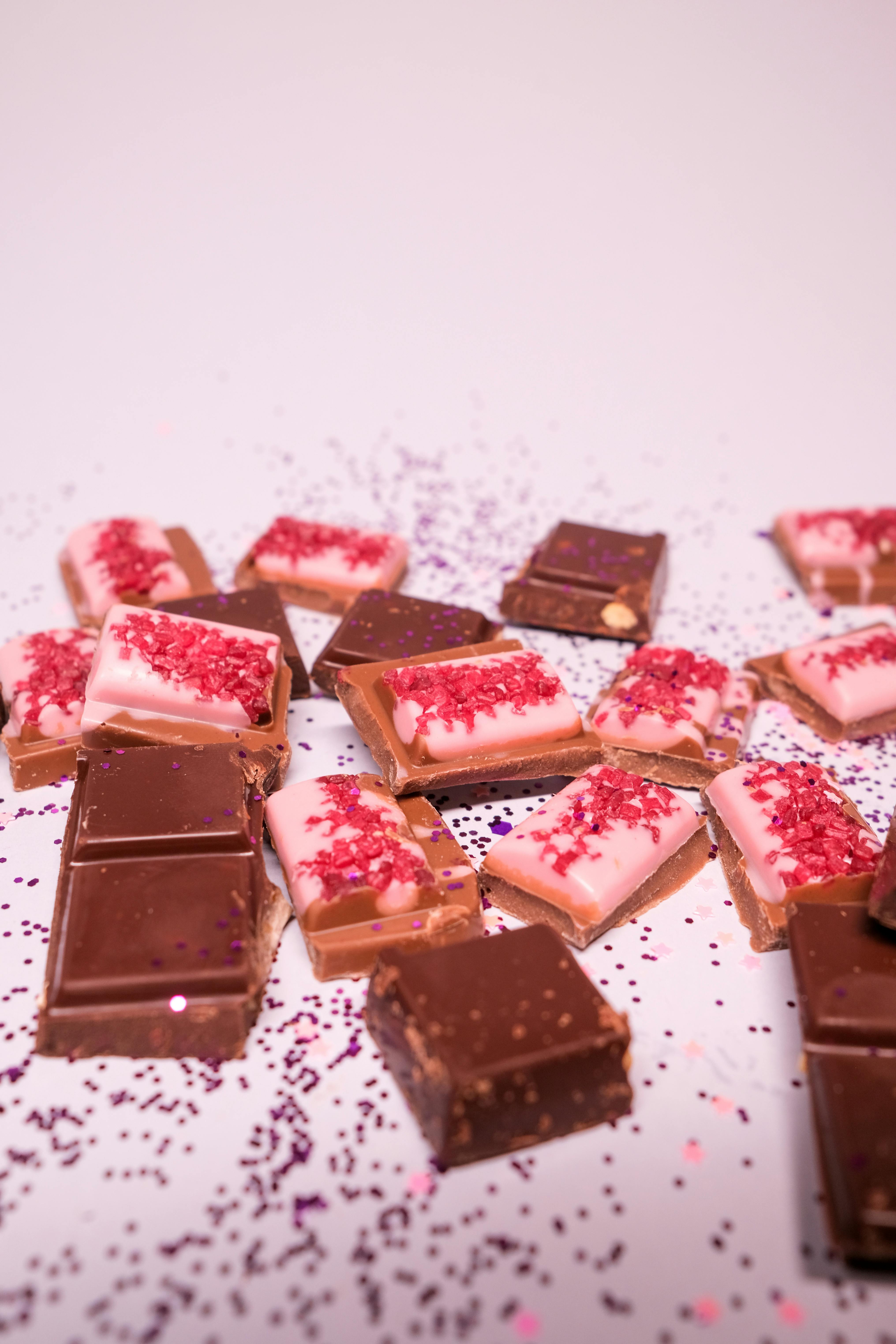 assorted chocolate bars scattered on white surface