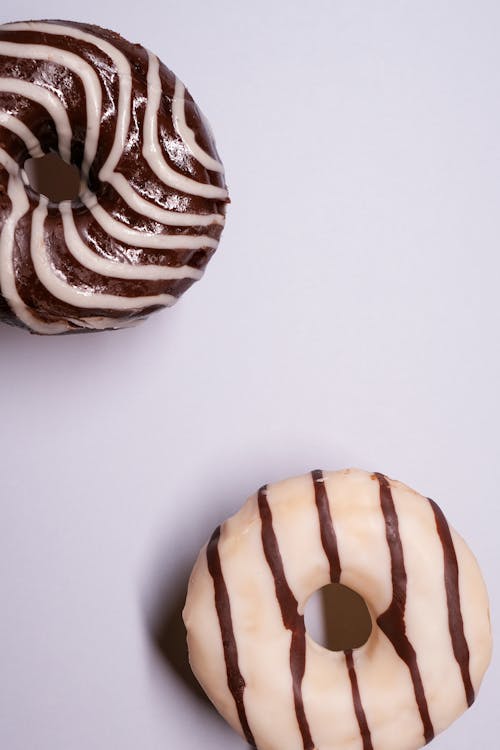 Appetizing glazed donuts served on gray surface