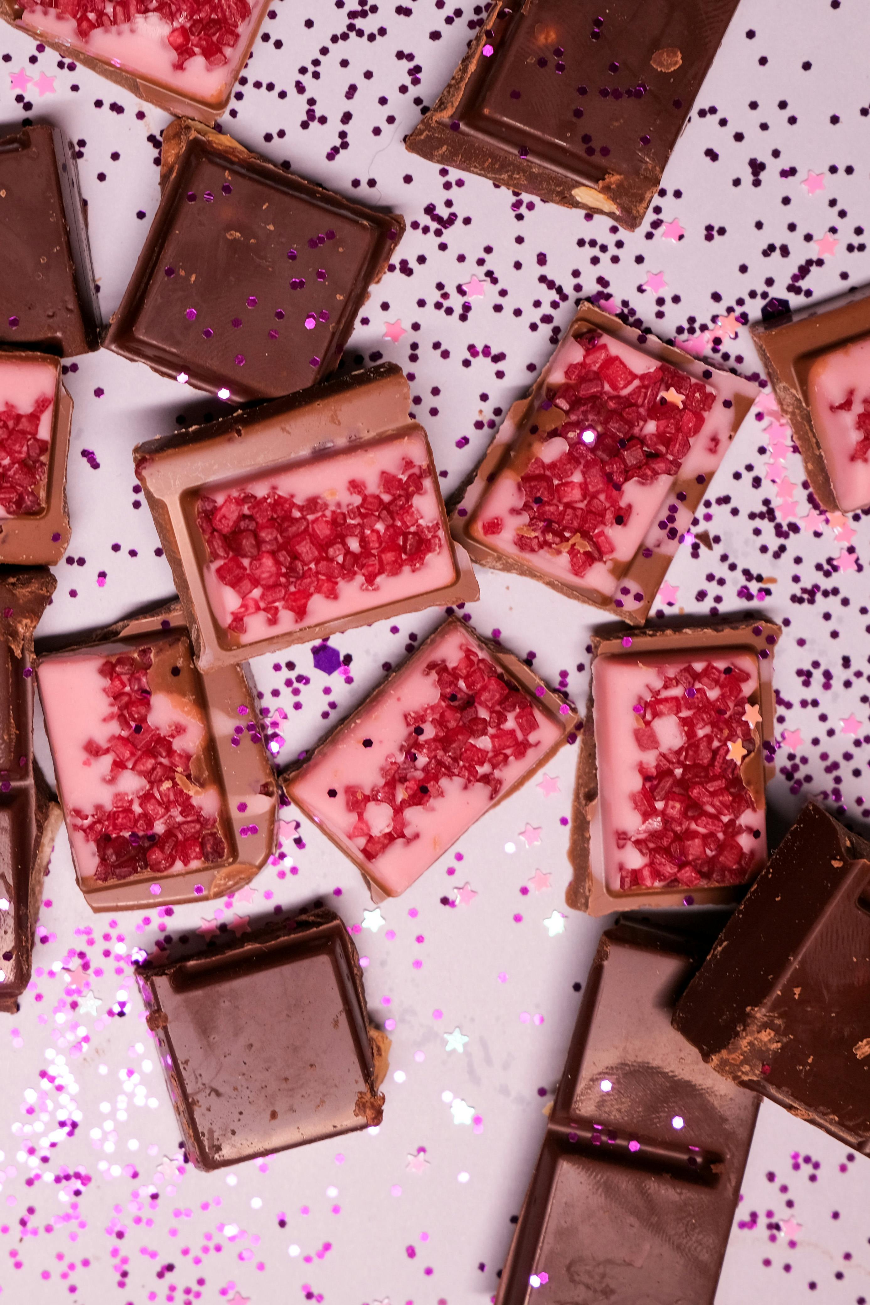 various yummy chocolate candies scattered on table with glitters