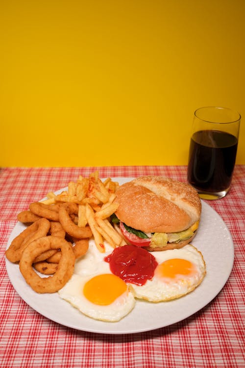 Plate with assorted fast foods served on table with glass of coke