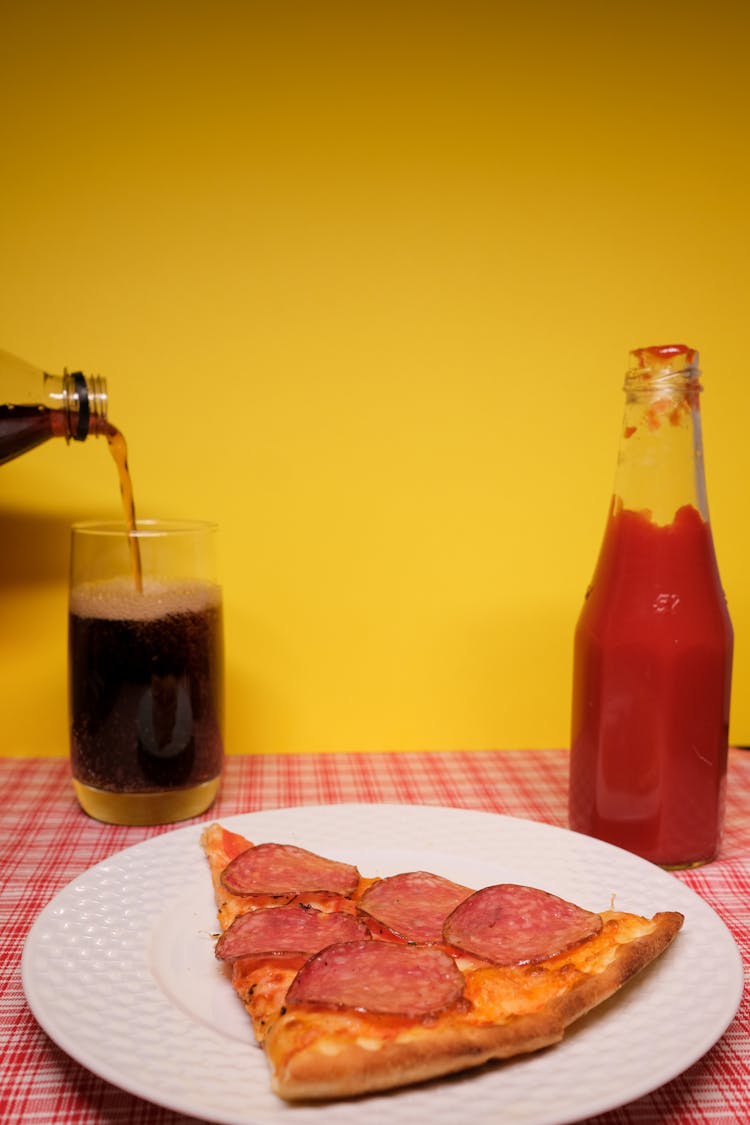 Plate Of Pizza Served On Table With Ketchup And Soft Drink