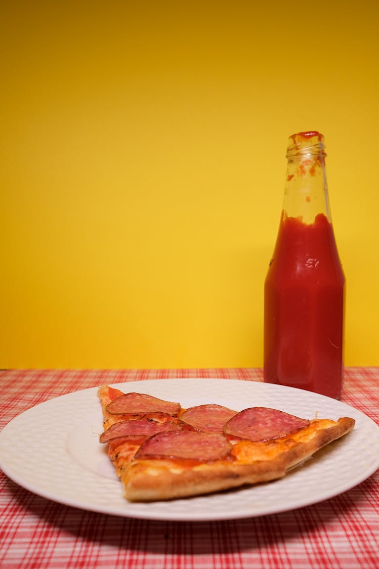 Pizza Served On Plate On Table With Bottle Of Ketchup