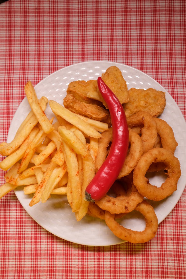 French Fries And Onion Rings With Nuggets And Chili Pepper