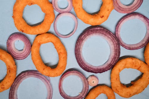 Onion rings and sliced onion on blue background