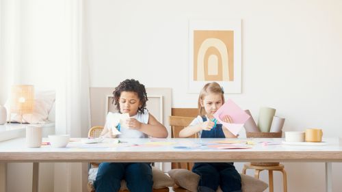 Free Two children enjoy cutting colorful paper for a creative art project indoors. Stock Photo
