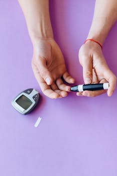 Person checking blood glucose level with glucometer on purple background.