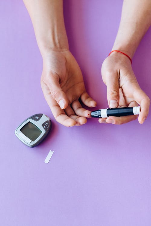 hands of someone checking their blood sugar with a glucometer
