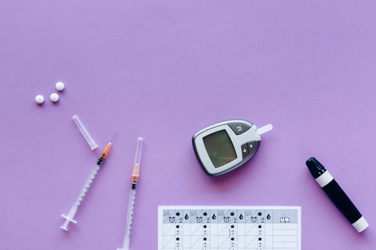 Diabetic Kit And Medicines Over A Purple Surface