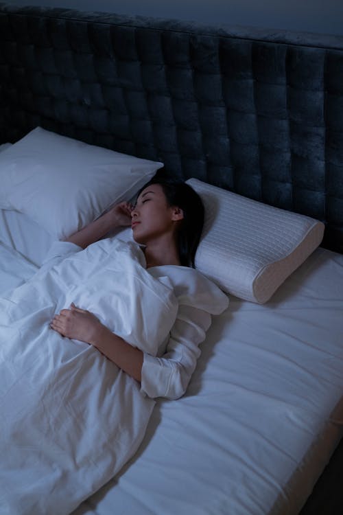 Free A Woman Sleeping in Her Bed Stock Photo