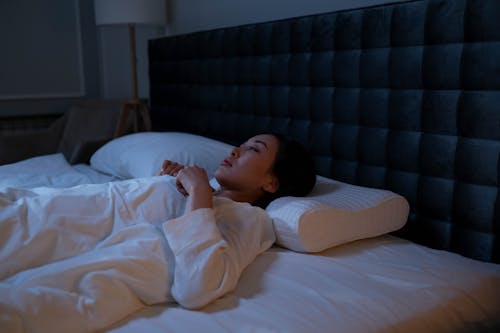 Free Woman in White Pajama Lying on the Bed Stock Photo