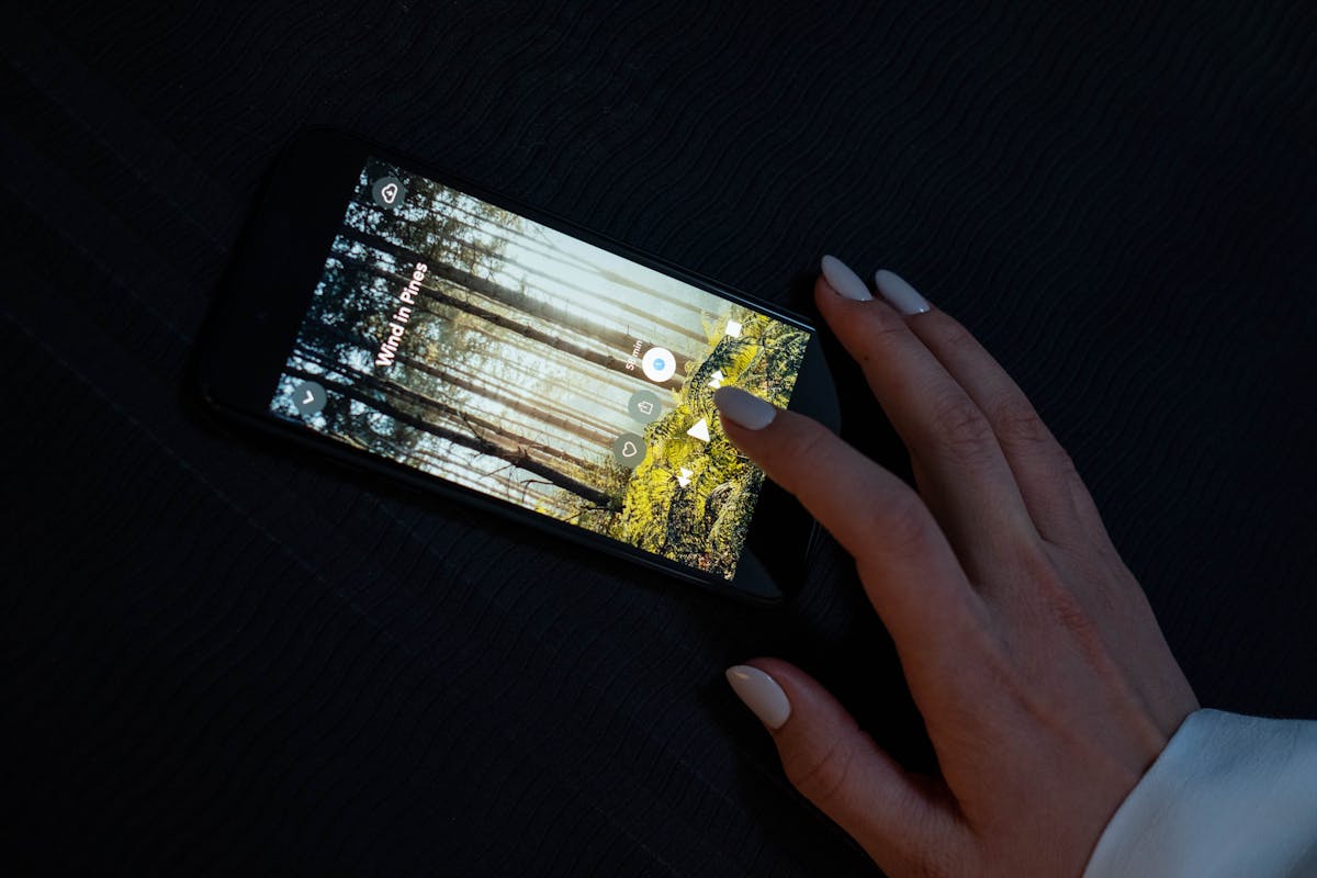 Mano che regola il volume su un'app musicale dello smartphone