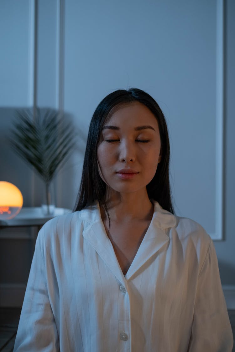 Portrait Of A Woman In White Pajamas With Her Eyes Closed