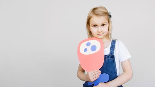 Girl Holding Her Artwork While Looking at the Camera