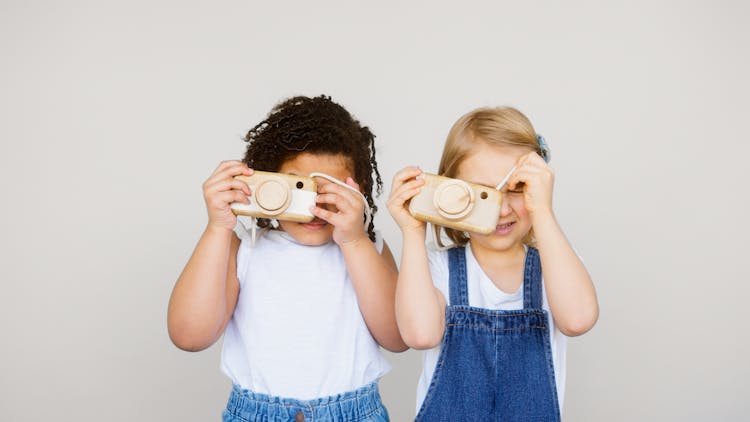 Two Kids Taking Photo Using A Camera