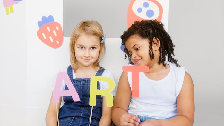 Two Kids Showing Their Artworks