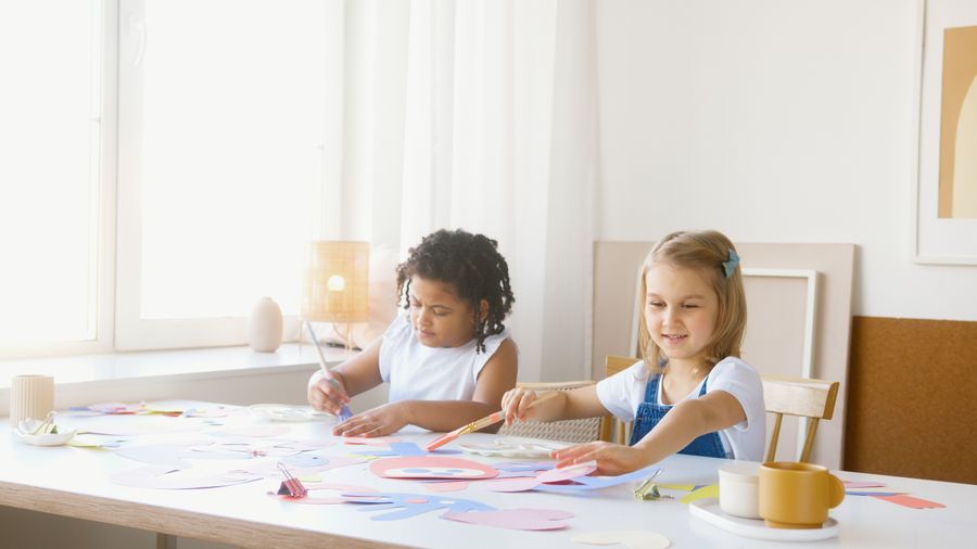 Due bambini che realizzano lavoretti creativi al tavolino