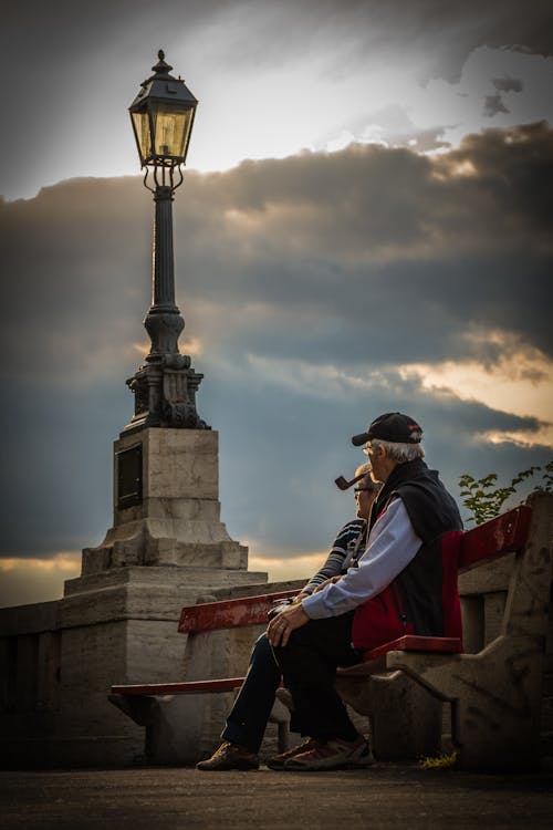 Man in Pipe Beside Woman Wearing Black Frame Eyeglasses during Day Time