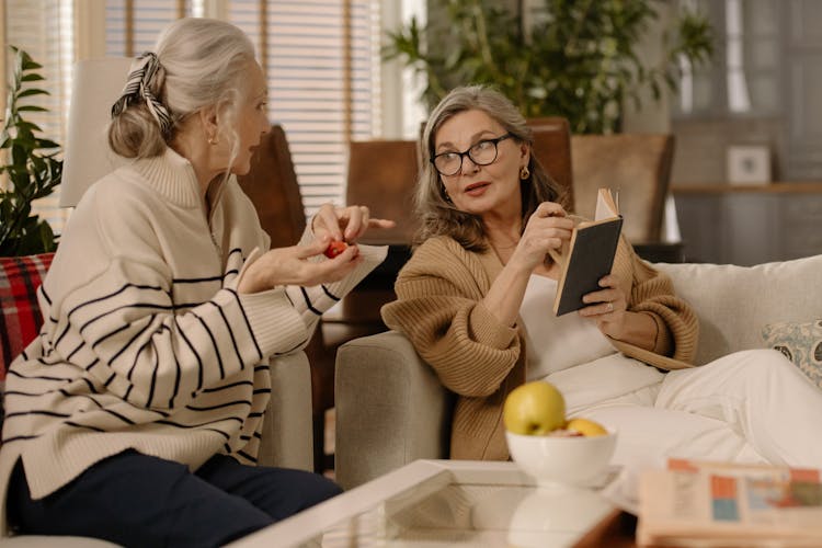 Two Elderly Woman Talking To Each Other While Sitting On A Couch