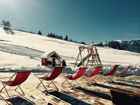 冬日天空明亮，白雪皑皑的度假胜地甲板上排列着椅子，非常适合放松