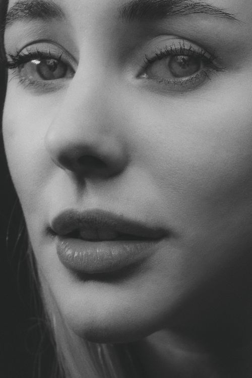 Free Grayscale close-up portrait of a woman's face, conveying emotion and detail. Stock Photo