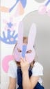 Girl Covering Her Face With a Cutout Animal Mask