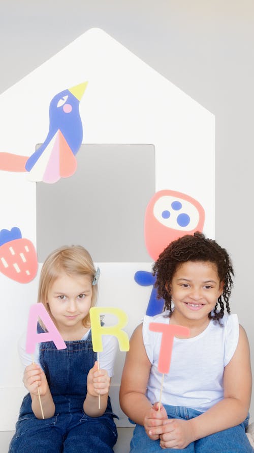 Two Kids Showing Their Artworks