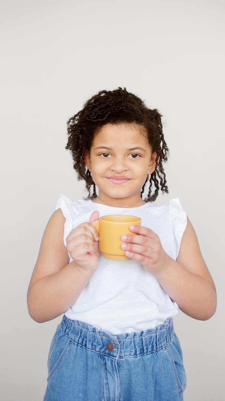 Girl In White Sleeveless Shirt Holding Yellow Cup