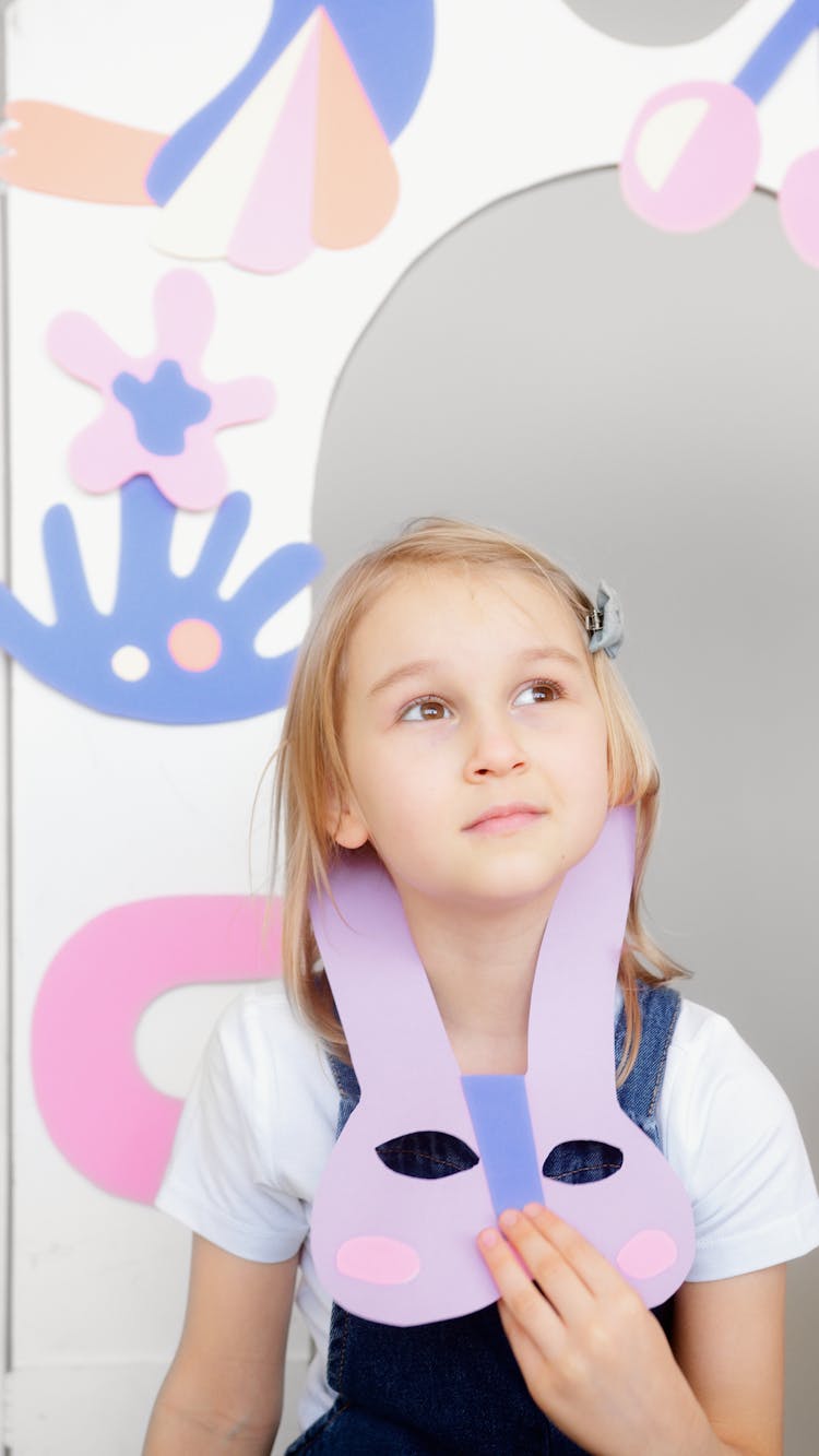 Girl Looking Upwards While Holding A Paper Animal Mask